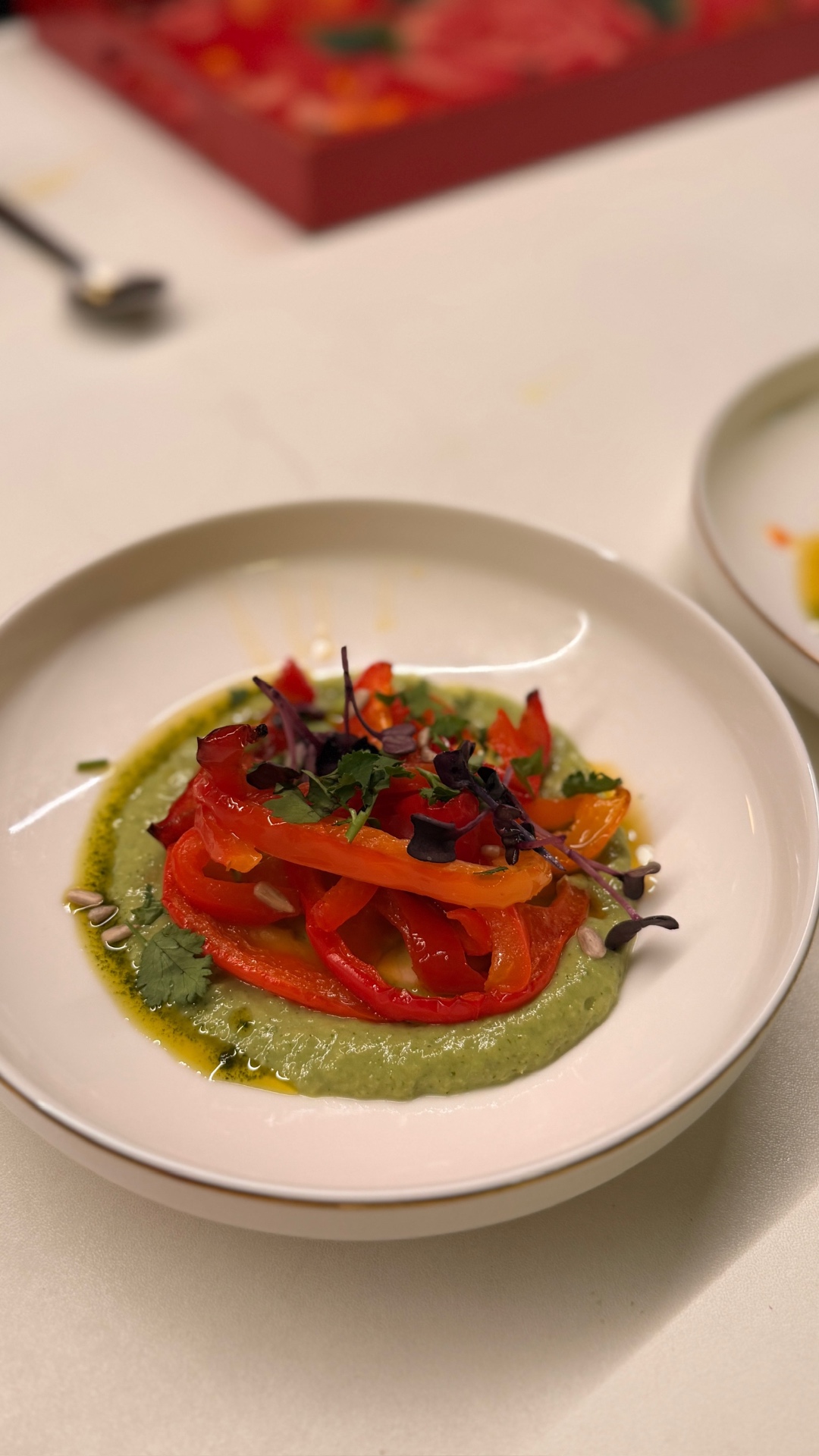 Roasted peppers with herbs on a green sauce