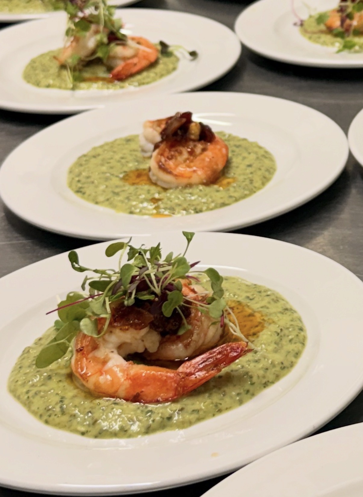 Prawns on a green herb sauce, plated for a private dinner
