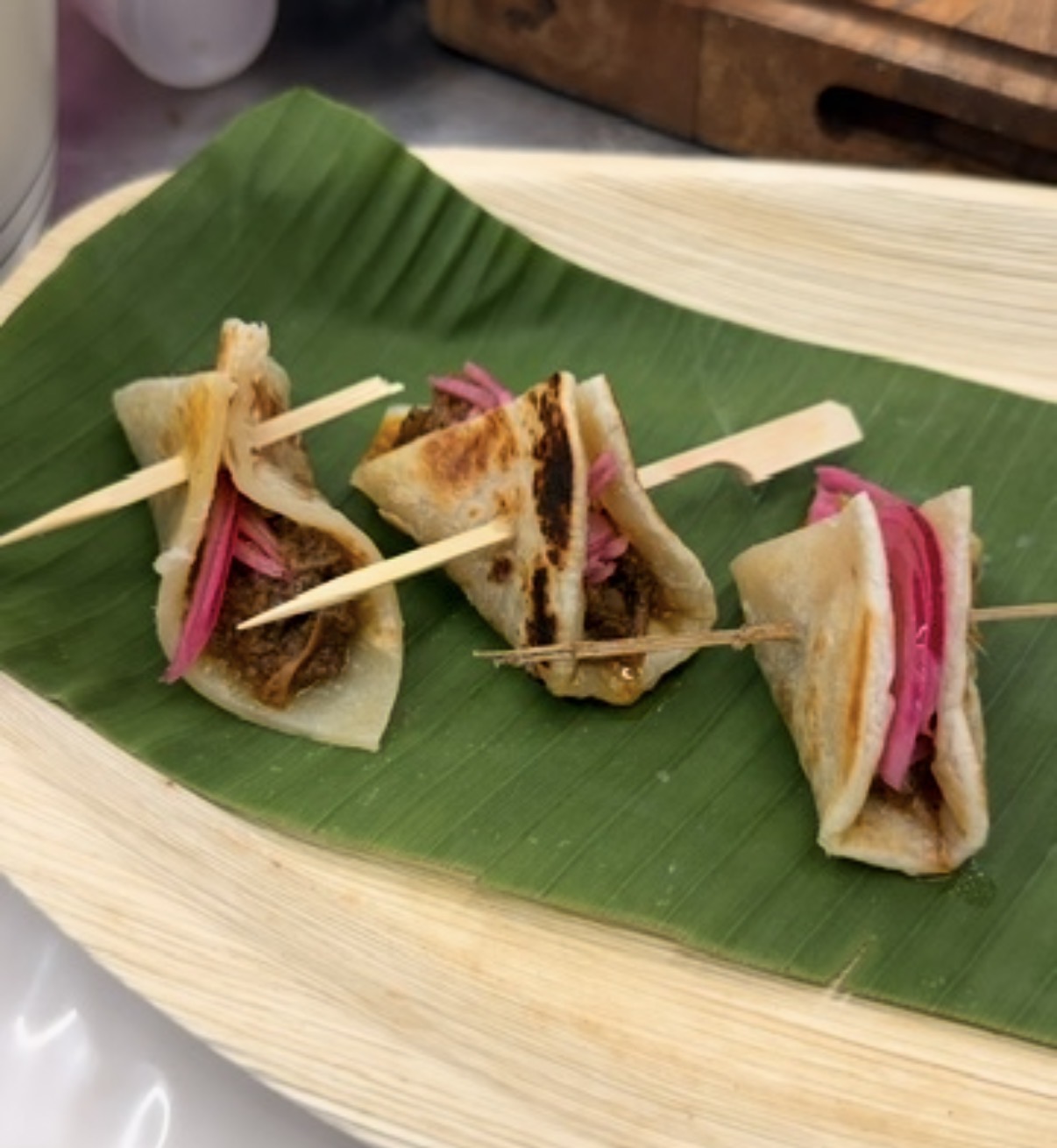 Parantha bites with beef and pickled onion on a banana leaf