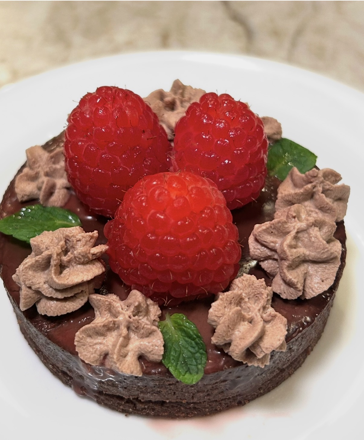 Chocolate raspberry tart with chocolate cream and mint