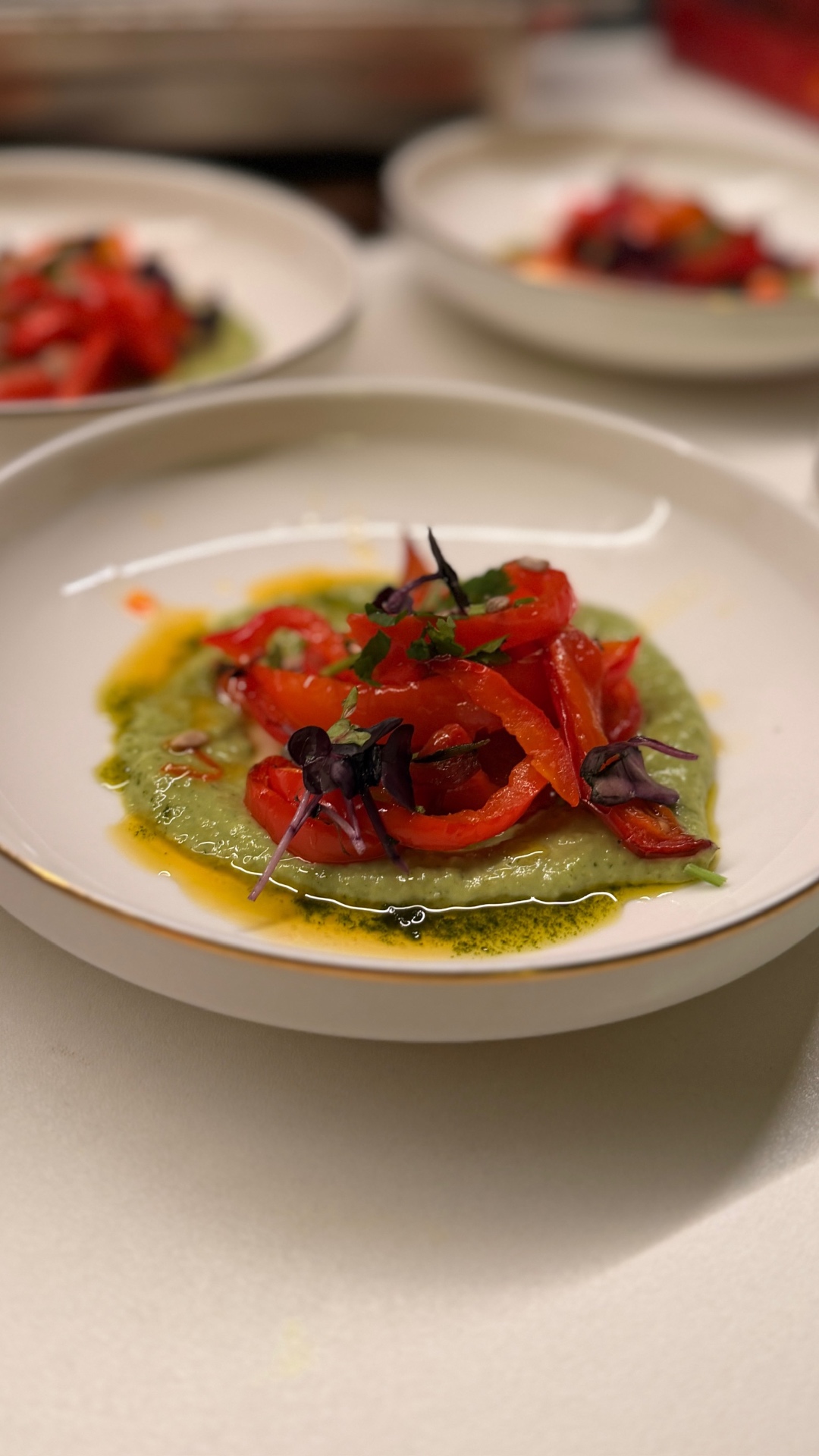 Roasted red peppers over a green purée, plated for a private dinner