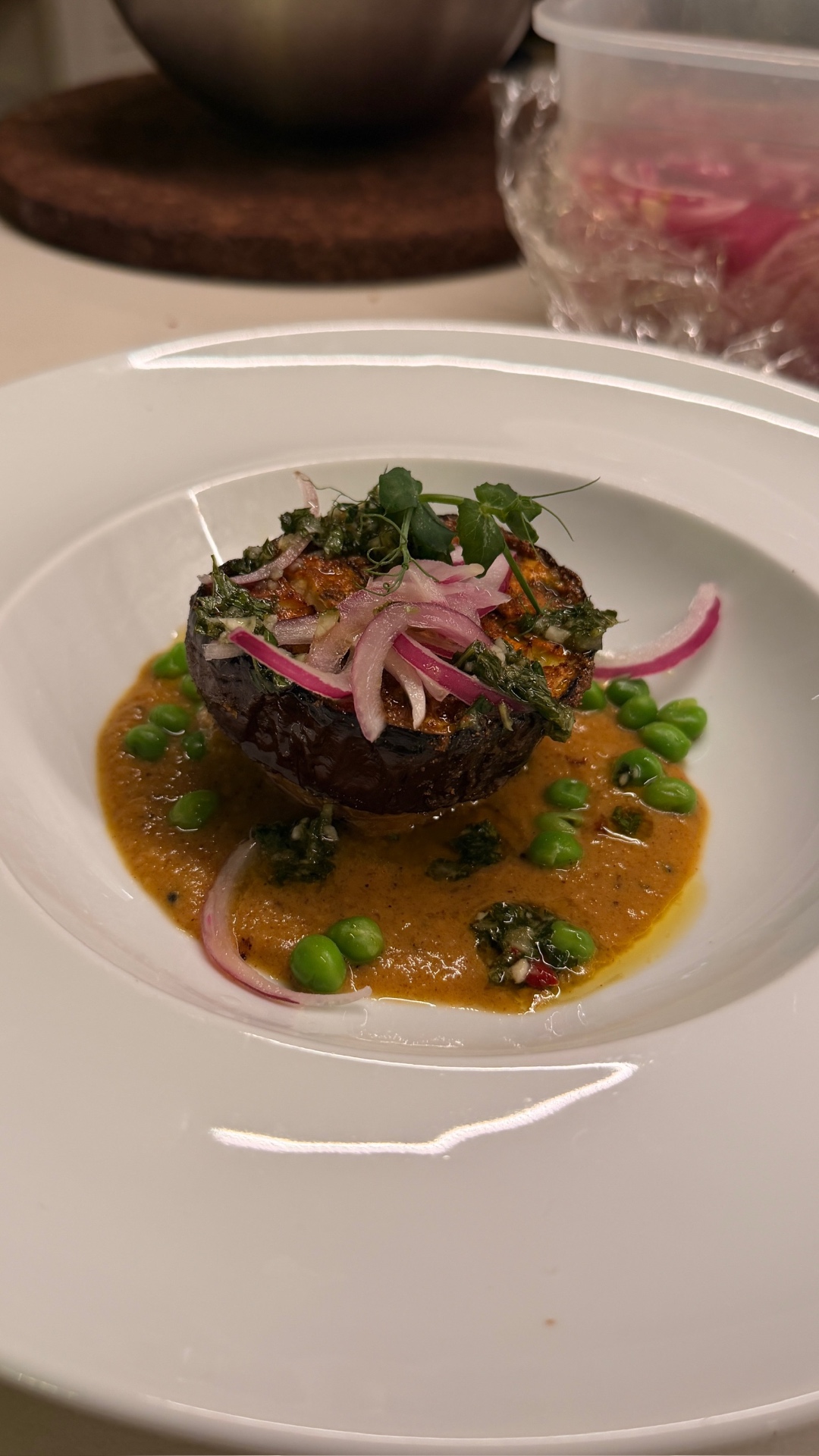 Aubergine with peas, pickled onion and herbs in a spiced sauce