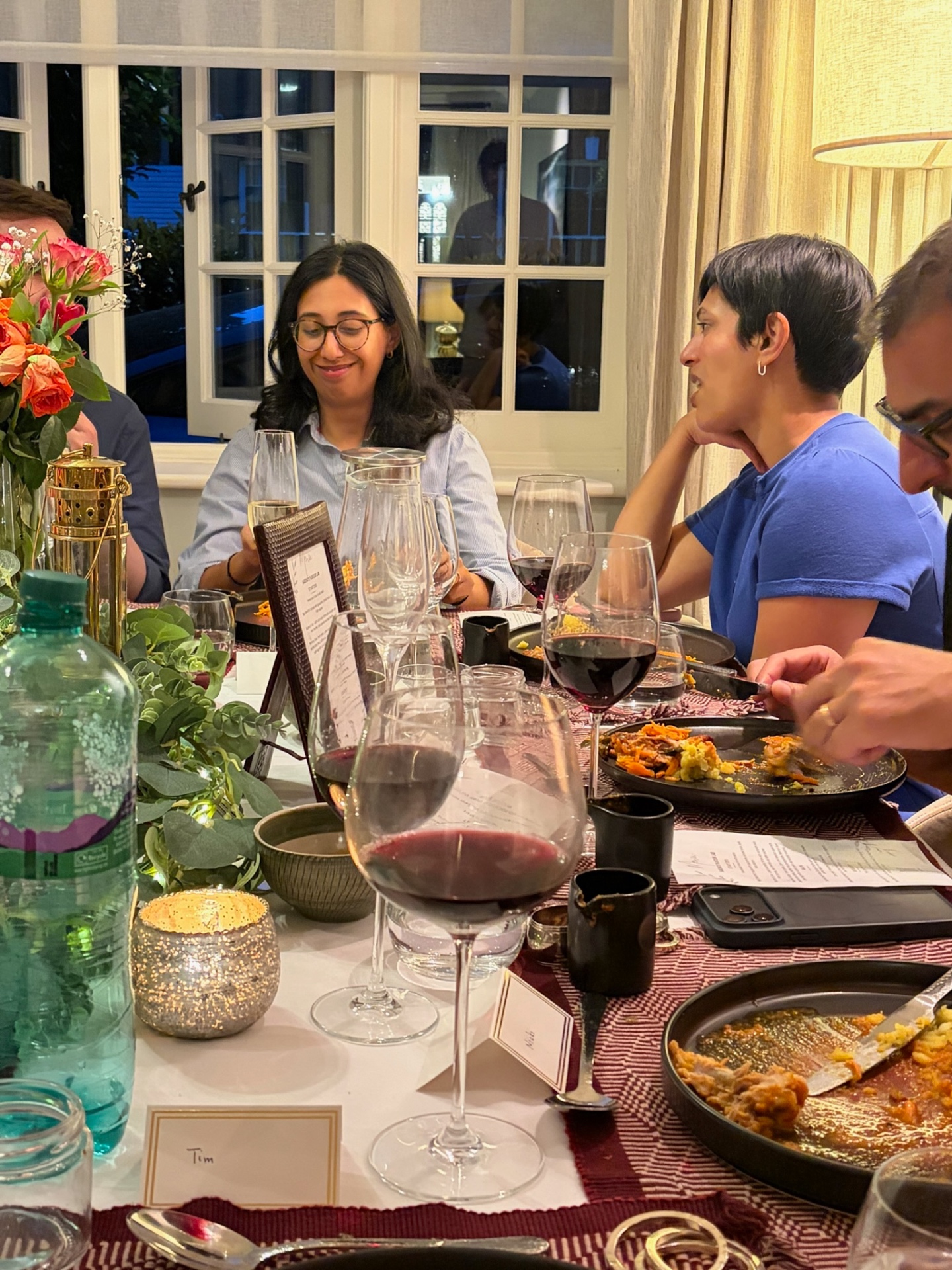Guests enjoying plated courses at a flower-filled supper-club table