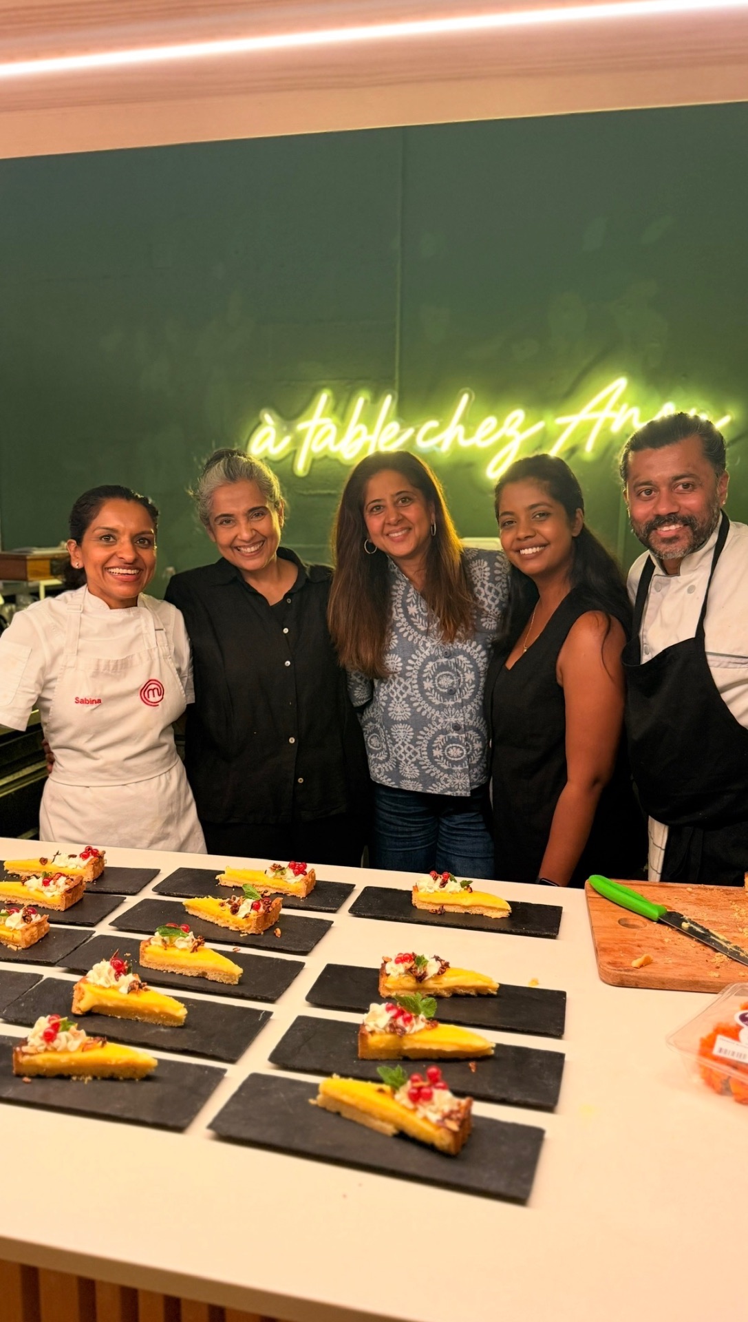Sabina with the group behind the Geneva pop-up, with plated desserts ready for service