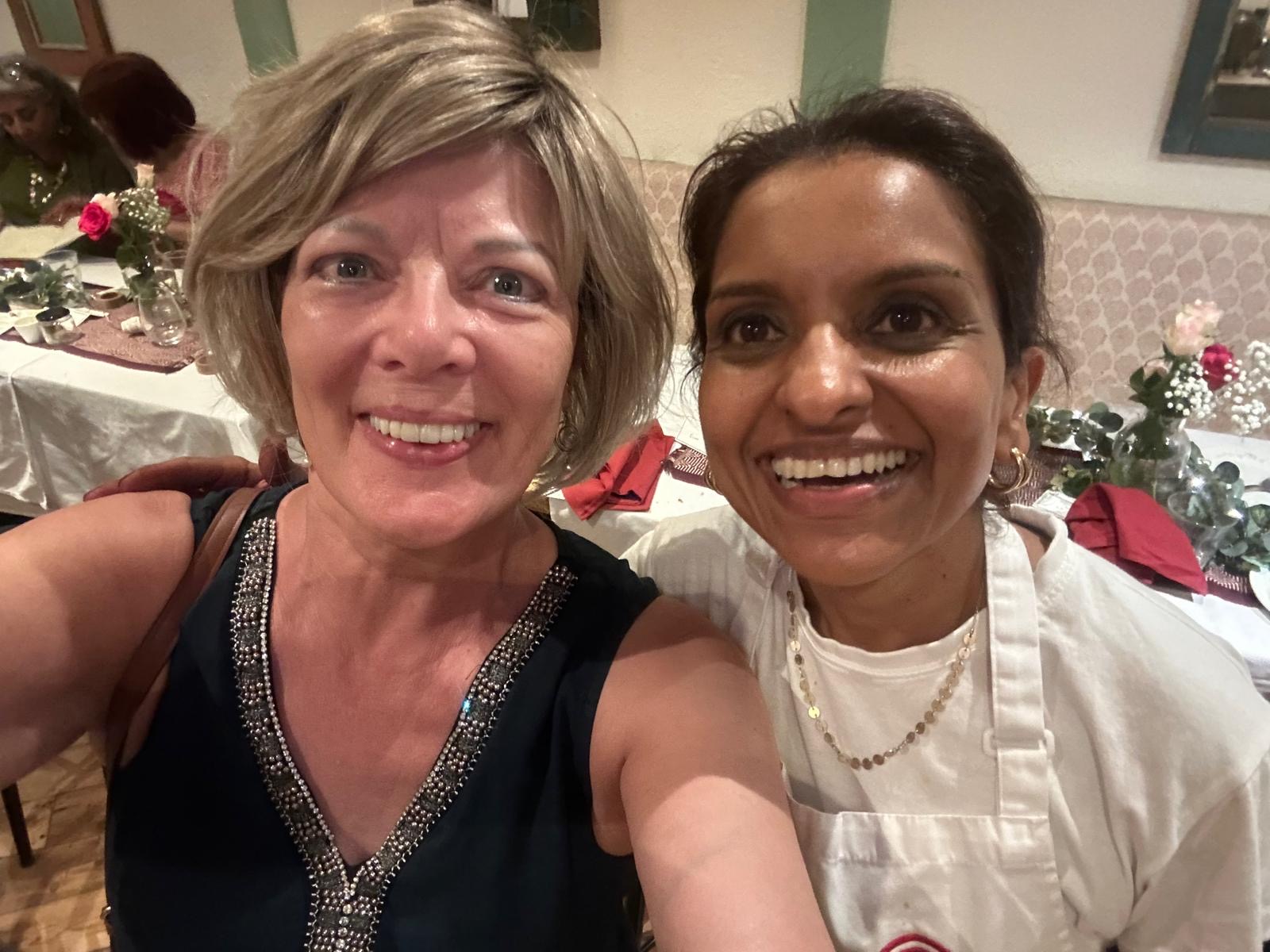 Sabina smiling beside a guest after supper club