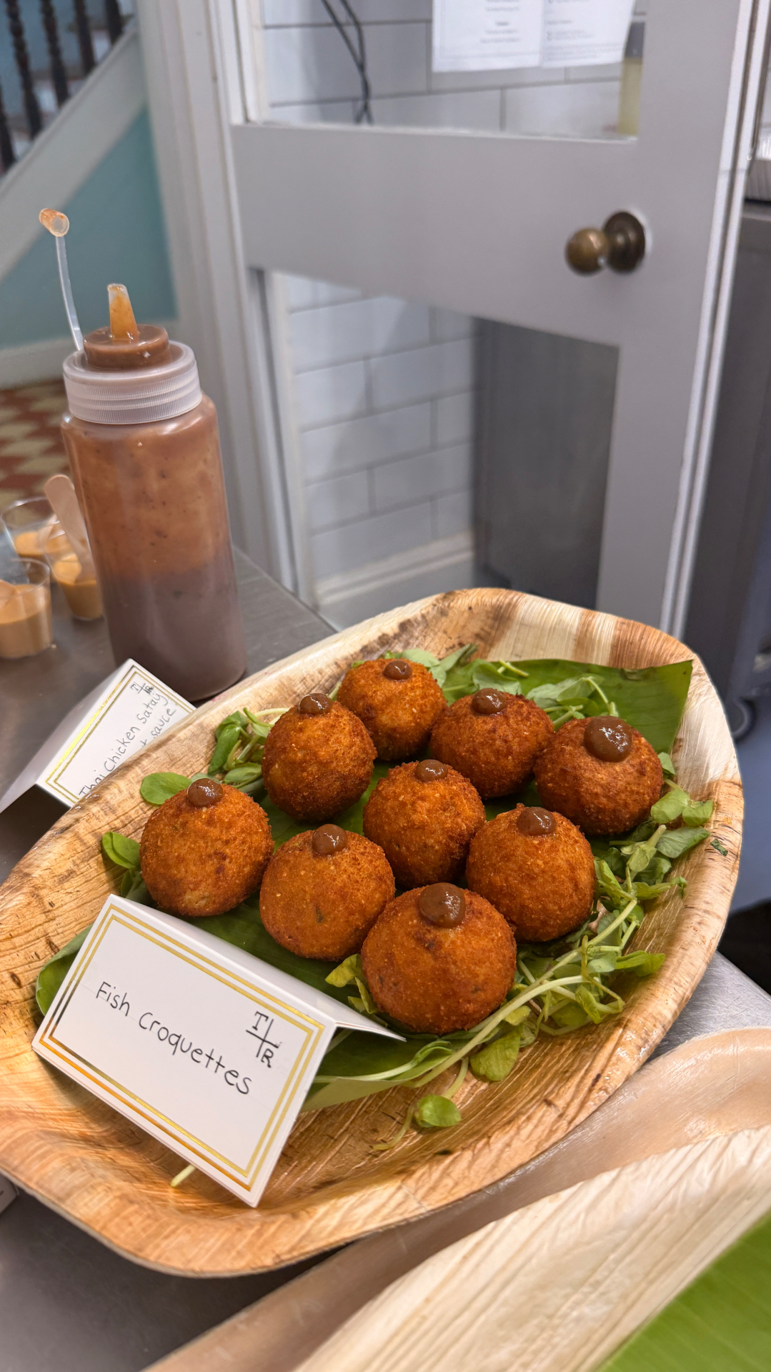 Fish croquettes on a banana-leaf platter for a small event